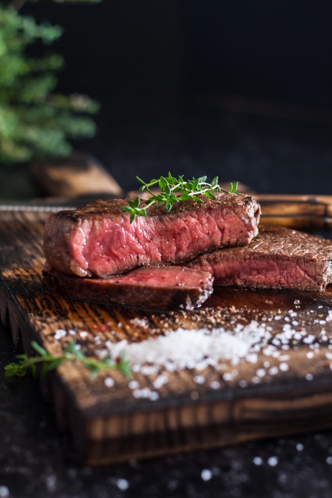 Mediumrare Sliced Beef Steak With Salt Herbs Wooden Board Dark Background